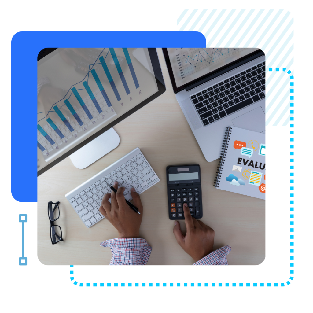 Hands using a keyboard and calculator on a desk with a laptop, graphs, and a notebook labeled "EVALUATION." Indicates analysis and productivity.